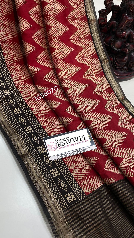 "Chic leaf print Dola silk saree with tassels, red with black, epitomizing elegance and style."